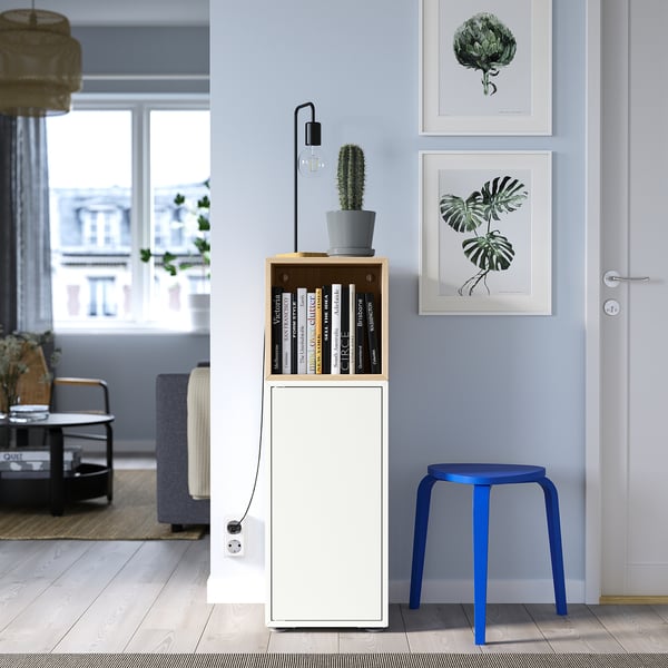 Sala d'estar moderna amb armari EKET, llibres, cactus, tamboret blau, estampats i seients acollidors.