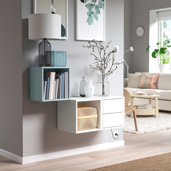 Sala d'estar moderna amb moble d'emmagatzematge EKET en blanc, compartiments mixtos oberts i tancats, decoració minimalista.