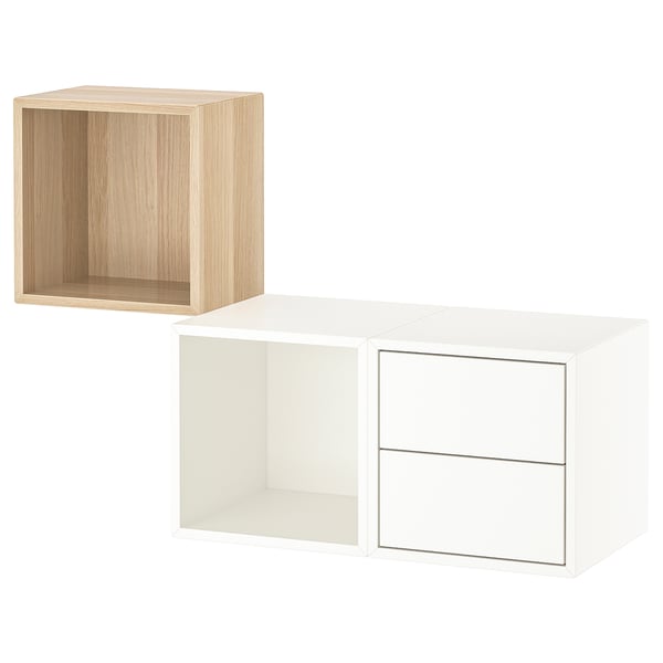 Dos cubs d'emmagatzematge moderns: un blanc i un altre de fusta clara. Forma quadrada, disseny minimalista, compartiments oberts i tancats.