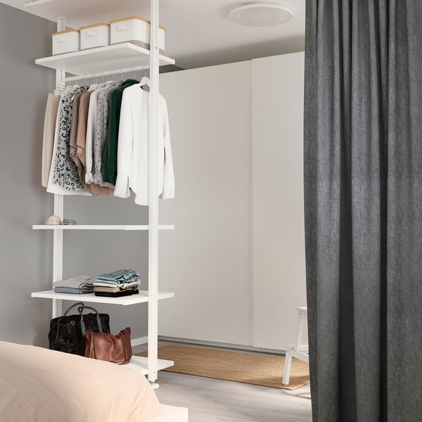 Armari modern d'ELVARLI blanc. Roba organitzada, habitació amb cortines, llit a l'esquerra.