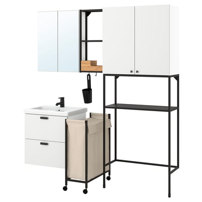 Configuració moderna del bany blanc: armari, lavabo, mirall, prestatges, bossa de roba i ganxos en negre i fusta.