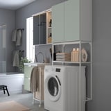 Combinació moderna de bugaderia-bany. Armaris de color verd clar, electrodomèstics blancs. Compacte però espaiós.