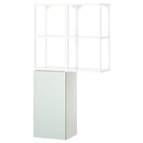 Un moble d'emmagatzematge ikea ENHET en color blanc amb calaixos de color verd clar, amb compartiments oberts i tancats per a un emmagatzematge versàtil.