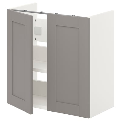Moble de paret de bany ikea ENHET gris amb dues portes. Té un disseny modern i està muntat a la paret. L'armari té dos prestatges a l'interior.