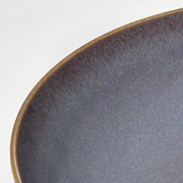 Bol vidriat blau, primer pla sobre blanc.