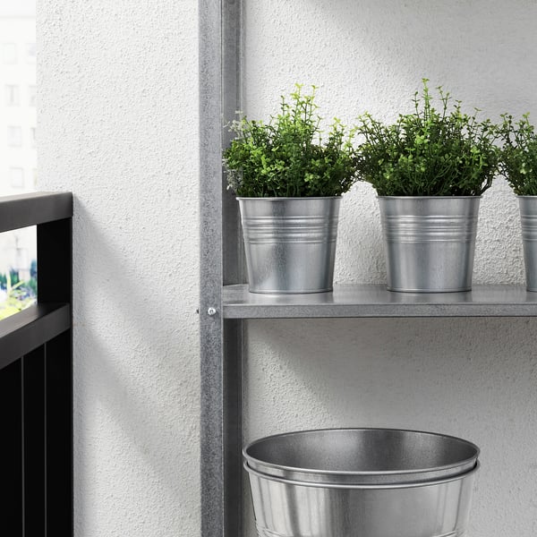 Plantes artificials en prestatge metàl·lic, decoració de baix manteniment.