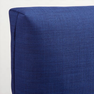Coixí entapissat blau, teixit texturitzat, ferm però suau. Ideal per a la comoditat.