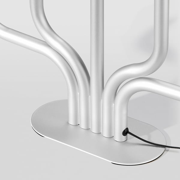 Base de llum de taula platejada moderna amb disseny elegant i corbat i cable d'alimentació.