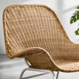Butaca de vímet amb respatller i braços corbats, fabricada en rotang teixit a mà, amb textura natural i disseny lleuger i còmode.