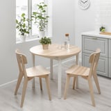 Menjador minimalista amb taula i cadires de fusta, perfecte per a espais compactes, decorats amb una planta.