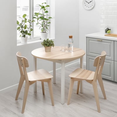 Menjador minimalista amb taula i cadires de fusta, perfecte per a espais compactes, decorats amb una planta.