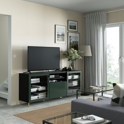 Armari GLASSVIK de color verd oliva amb tv, sofà gris, taula de cafè i art de paret.