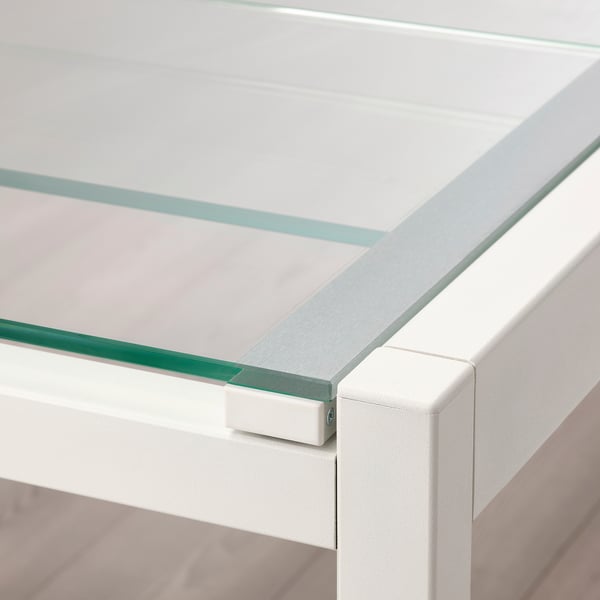 Primer pla de la taula de vidre moderna amb un marc metàl·lic resistent; disseny elegant i minimalista.