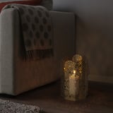 Llanterna GOKVÄLLÅ a terra al costat del sofà; petita, octogonal, il·luminada, resplendor metàl·lica.