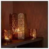 Llanternes decoratives amb llum càlida. Centre de taula amb intricats dissenys florals. Metall i acrílic, color blanc.