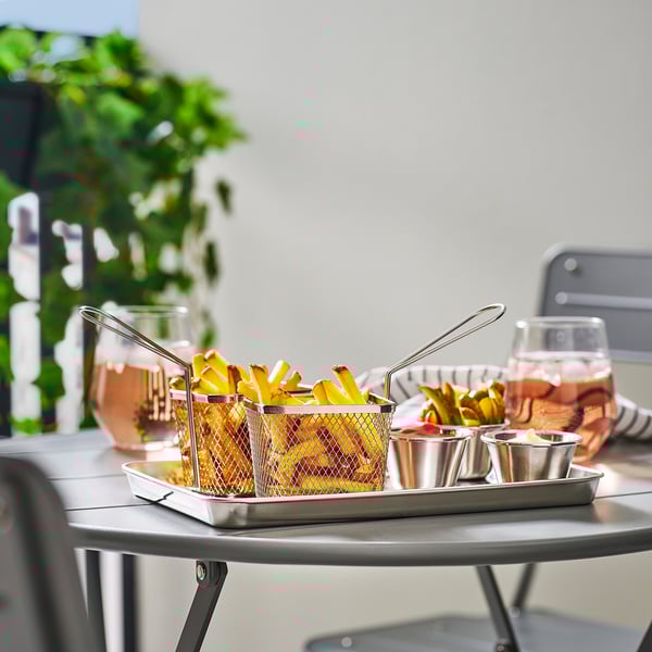 Safata de servir GRILLTIDER d'acer inoxidable amb fregits i salses, al costat de gots.