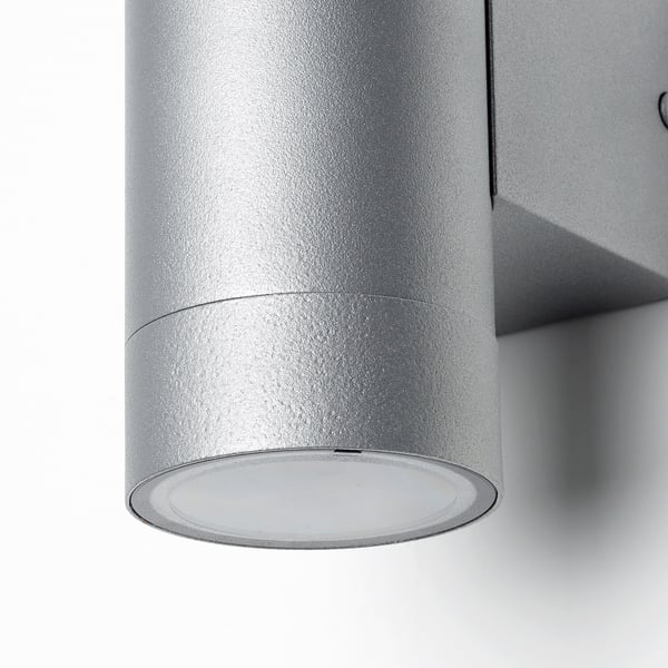 Llum exterior moderna amb un disseny elegant d'acer inoxidable, que emet una brillantor càlida.