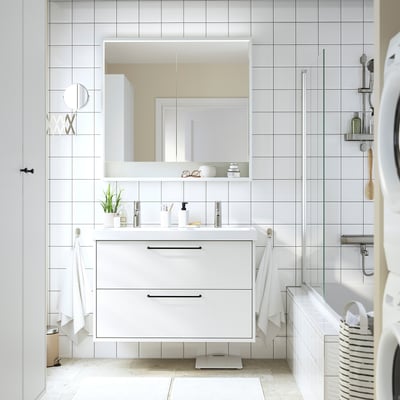 Tocador de bany blanc modern: lavabo doble, dos calaixos, paret, decoració minimalista, mirall espaiós.