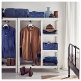 Dormitori modern amb armari blanc HEMNES, roba blava, botes, barret i objectes decoratius.
