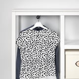 Un armari de fusta blanca amb una camisa penjant, que mostra la seva funció d'emmagatzematge de roba.