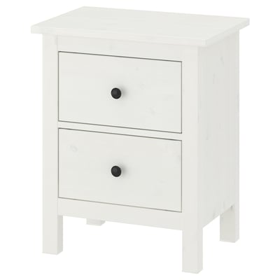 Una calaixera de fusta blanca HEMNES amb dos calaixos, cadascun amb poms negres, sobre quatre potes.