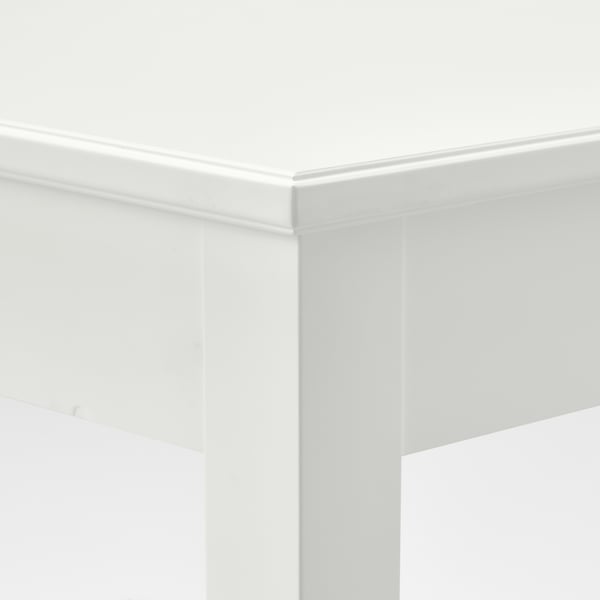 Racó blanc nítid d'un elegant conjunt de menjador. Les línies netes destaquen l'artesania de qualitat.