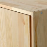 Primer pla de mobles IVAR de fusta de pi resistent. Mostra vores llises i un mecanisme lliscant elegant.