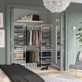 Vestidor modern amb emmagatzematge JONAXEL, seients, catifa fosca, parets clares.
