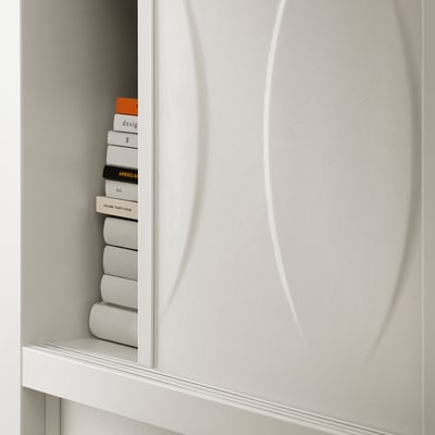 Armari blanc KALKNÄS amb portes corredisses de vidre, mostrant llibres ben apilats. Disseny modern i minimalista.