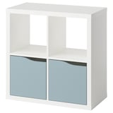 Una prestatgeria KALLAX blanca amb dos calaixos blaus. És un disseny modern amb forma quadrada. Els calaixos tenen portes reflectants.