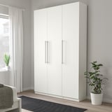 Gran armari blanc KALLRÖR al costat d'una planta i finestra, amb tiradors d'acer inoxidable.