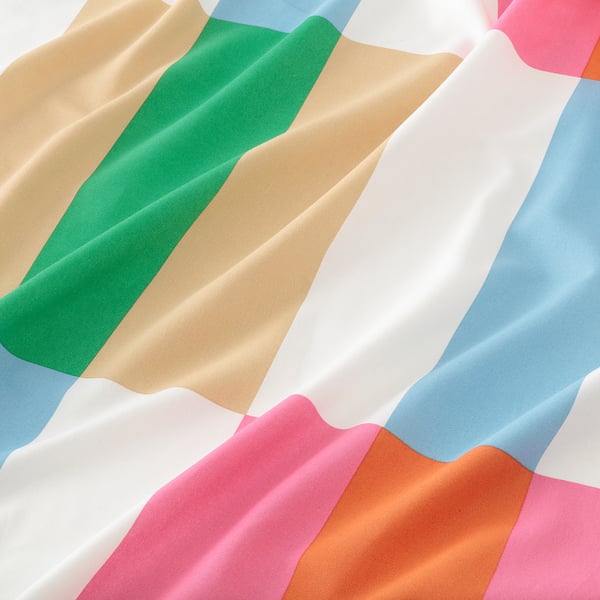 Teixit de cotó vibrant, d'alta qualitat i pretallat amb patrons geomètrics de colors sobre blanc, llest per a projectes de costura.