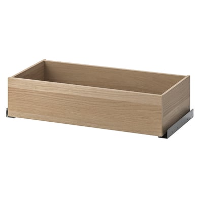 Un calaix de fusta ikea KOMPLEMENT, marró clar, rectangular, d'aspecte minimalista. És un mecanisme de tancament lent.