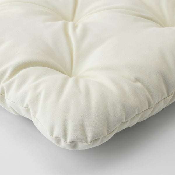 Coixí de peluix de color crema amb costures a mida, que mostra el seu material còmode i d'alta qualitat.