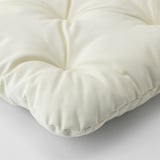 Coixí de peluix de color crema amb costures a mida, que mostra el seu material còmode i d'alta qualitat.