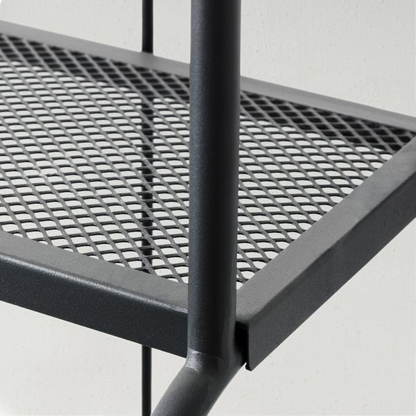 Prestatgeria metàl·lica negra amb patró perforat, suport vertical resistent, apte per a ús exterior.