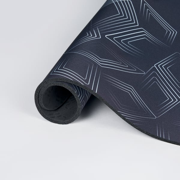 Coixinet de ratolí negre enrotllat amb disseny estampat blanc. Part superior de polièster reciclat, part inferior de goma adherent, superfície llisa per a un joc precís.