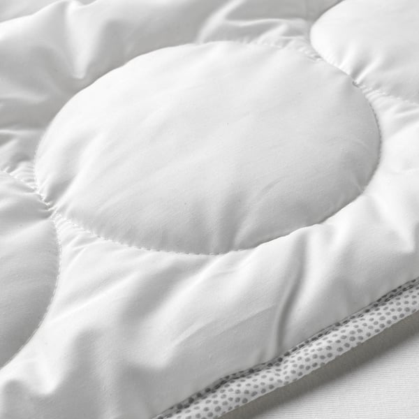 Primer pla en blanc i negre d'un nòrdic suau i texturitzat per a nadons amb patrons circulars, que mostra teixits i costures d'alta qualitat.