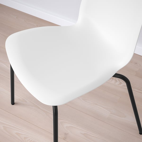Cadira blanca moderna, disseny elegant, seient corbat, potes metàl·liques negres. Perfecte per a una decoració minimalista.