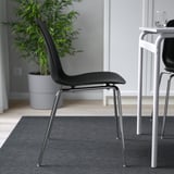 Cadira negra elegant amb respatller corbat, potes cromades. Apilable i fàcil de netejar. Perfecte per a menjars moderns.