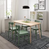 Conjunt de menjador modern amb taula de fusta clara i cadires verdes, línies netes, disseny minimalista; s'adapta bé a l'habitació lluminosa i airejada.