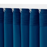 Les cortines de bloqueig de color blau fosc amb ganxos pengen perfectament, garantint la privadesa i el control de la llum.
