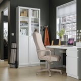 Conjunt modern d'oficina a casa amb escriptori blanc malm, cadira millberget i emmagatzematge. Terra de fusta clara, parets fosques.