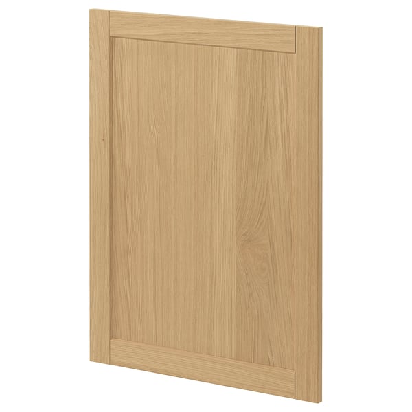 Una porta de l'armari de cuina de fusta marró clar amb un disseny senzill i emmarcat amb vores bisellades.