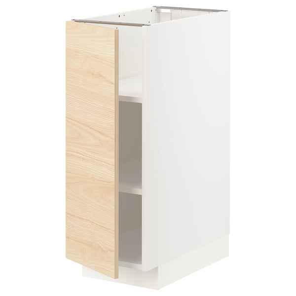 Un armari de cuina METOD amb una porta askersund de fusta de freixe clar. És un marc blanc i té un prestatge ajustable a l'interior.
