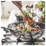 Wok d'acer inoxidable cuinant verdures de colors a la cuina, pujant al vapor.