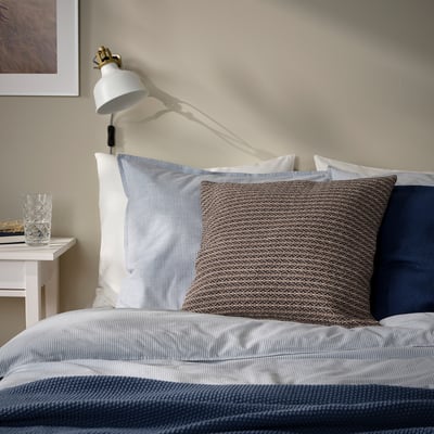 Llit amb coixí MOROTSMOTT gris-beix, coixins de ratlles, aplique.