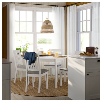Taula de menjador rodona blanca Ikea NÄSINGE amb tapa llisa i potes de fusta.