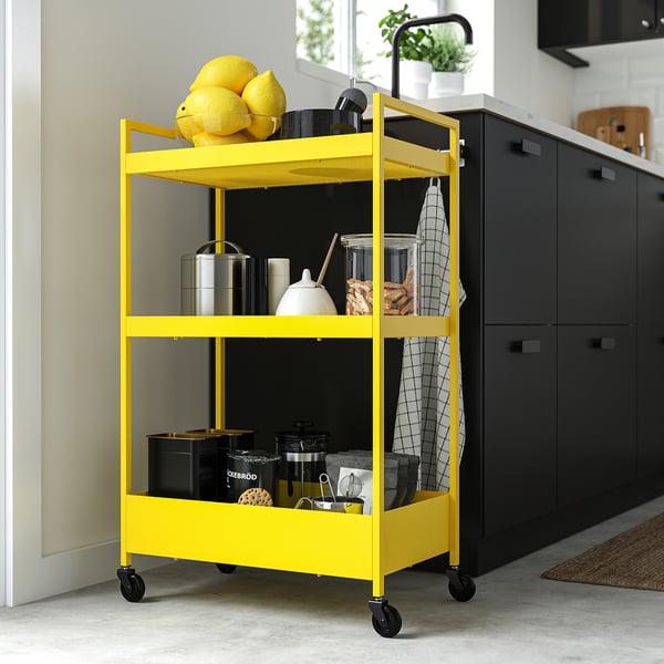 Carro de cuina groc ikea NISSAFORS de 3 nivells amb llimones, gerres i eines.