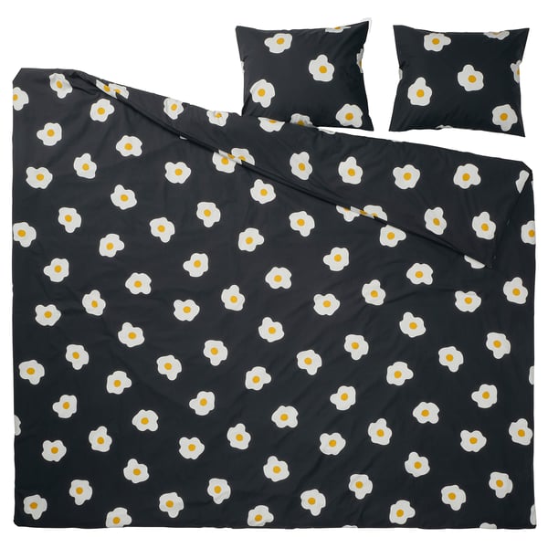 Llit ÖGONLOCKSMAL en color negre amb un estampat de flors blanques. El conjunt inclou una funda nòrdica i dos coixins, fets amb una barreja de cotó i viscosa.